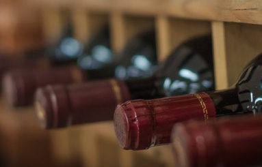 Red wine bottles stacked on wooden racks